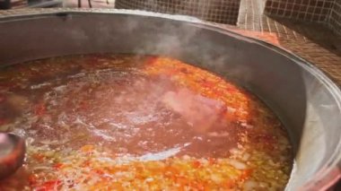 Şef, et çorbasını büyük bir kazanda sebzelerle karıştırıyor. Yavaş Hareket, Kapat.