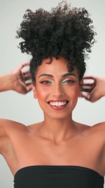 Siyah kıvırcık saçlı ve parlak makyajlı esmer bir kadının portresi. Gülümsüyor ve gülüyor. Kapat, Yavaş Hareket