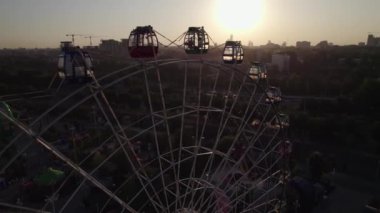 Bir dron lunaparkın üzerinde atlı karınca ve dönme dolap ile uçuyor. Hava görünümü.