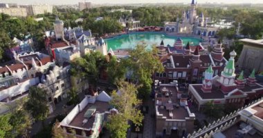 İnsansız hava aracı, bir eğlence parkının şatosunun üzerinde şarkı söyleyen bir çeşmeyle uçuyor. Hava Görünümü, Yavaş Hareket.