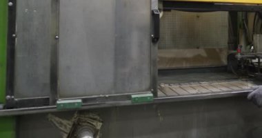 Fabrikanın montaj atölyesindeki ev aküsünün radyatörü su banyosuna batırılarak test edilir. Yavaş Hareket.