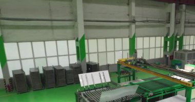 İHA otomatik bir taşıyıcıyla büyük bir atölyede uçuyor. Yavaş Hareket