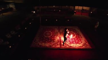 İnsansız hava aracı, Arap halısında gece vakti ateşle dans eden bir dansçıyı filme alıyor. Hava Görünümü.