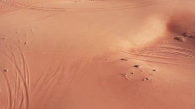 İnsansız hava aracı çölün kum tepelerinin üzerinden uçuyor. Hava görünümü.