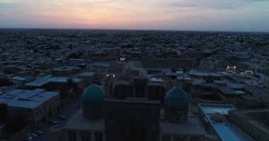 Özbekistan 'ın Buhara kentindeki eski evler arasında Poi-Kalon mimari kompleksinin üzerinde bir dron uçuyor. Erkenden bulutlu bir sabah. Hava Görünümü.