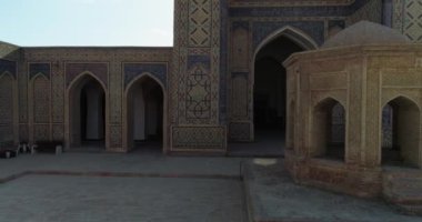 İnsansız hava aracı antik Lyab-i Hauz kompleksinin avlusunda turistlerle birlikte uçuyor. Eski Buhara, Özbekistan. Hava Görünümü.