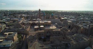 Güneşli ve bulutlu bir günde antik bir Kalyan Minaresi 'nin kulesinin üzerinde bir dron uçuyor. Eski Buhara, Özbekistan. Hava Görünümü.