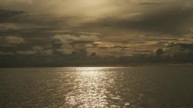 Gün batımında denizin sakin dalgaları. Arka planda fırtına öncesi bulutlu güzel bir gökyüzü. Maldivler. Yavaş Hareket
