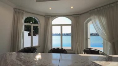 Oturma odasında, özel bir villada. Pencerelerden içeri güneş ışığı giriyor. Yavaş Hareket.