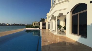 Bir İHA Dubai 'de yüzme havuzu olan lüks bir özel villanın önünde uçuyor. Yavaş Hareket.