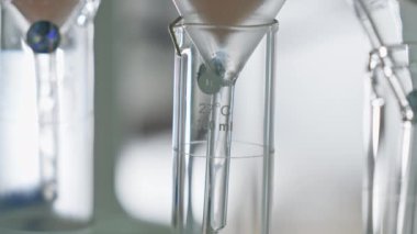 Sıvıyı filtreden geçirip cam laboratuarının mucizesine sokuyor. Kimyasal laboratuvar, ağır çekim..