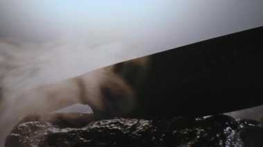 Pahalı, özel bir bıçak. Taşlar arasında duman bulutları arasında kaliteli bir tasarımı var. Yavaşça kameranın önünde dönüyordu. Yakın plan.