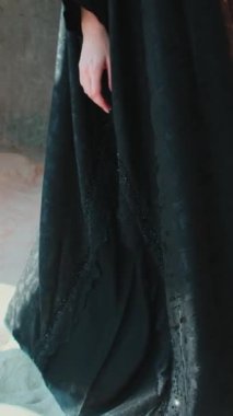 Abaya 'nın Arap ulusal elbisesi içinde yalınayak genç bir kadın. Elbisenin yakın çekimi. Yavaş Hareket.