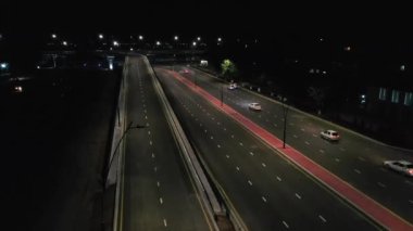 Yoldan geçen arabalarla bir gece köprüsünün üzerinde insansız hava aracı. Hava Görünümü