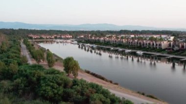 Göldeki küçük bir kasabanın üzerinde bir dron. Marinalar, bulutlu yaz günbatımı. Sibari, İtalya. Hava Görünümü