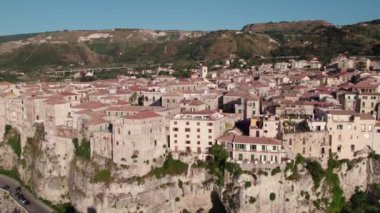 Uçurumlardaki antik bir sahil şehrinin üzerinde bir dron. Sakin deniz, bulutsuz bir gün. Tropea, İtalya. Hava Görünümü.