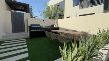 Güneşli bir günde Dubai 'de özel bir villanın arka bahçesinde küçük bir yüzme havuzu ve kanepesi var. Dışarıda ağır çekim.