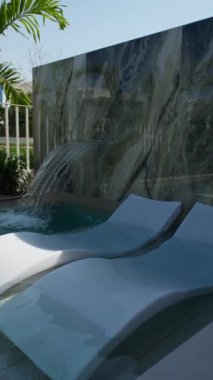 Güneşli bir günde Dubai 'de lüks bir villanın arka bahçesinde küçük özel bir yüzme havuzu. Dışarıda, Yavaş Hareket.