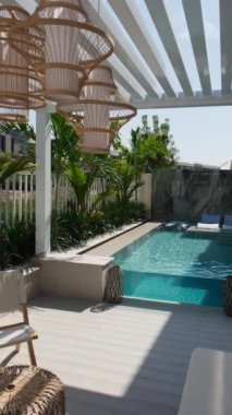 Güneşli bir günde Dubai 'de özel bir villanın arka bahçesinde küçük bir yüzme havuzu ve kanepesi var. Dışarıda ağır çekim.