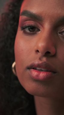 Afro saçlı ve parlak makyajlı esmer bir kadının portresi. Yavaş Hareket