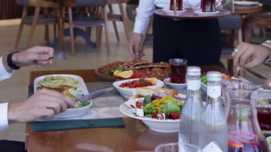 İnsanlar restoranda bir masaya oturur ve yemek yerler. Kapat, Yavaş Hareket.