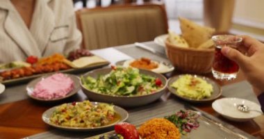 İnsanlar restoranda bir masaya oturur ve yemek yerler. Kapat, Yavaş Hareket.