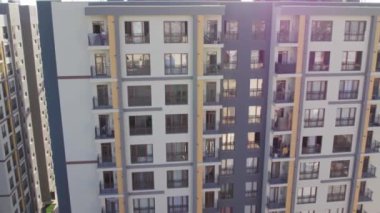 İnsansız hava aracı güneşli yaz gününde apartmanların üzerinden uçuyor.