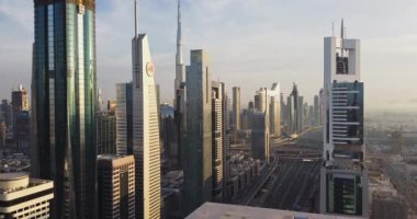 İHA Dubai, BAE 'de helikopter pisti olan bir gökdelenin tepesinde uçuyor. Güneşli bir gün, Hava Görüntüsü.