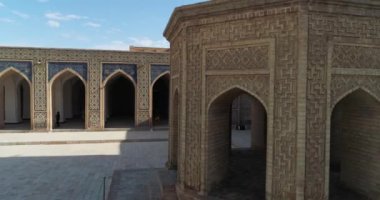 İnsansız hava aracı antik Lyab-i Hauz kompleksinin avlusunda turistlerle birlikte uçuyor. Eski Buhara, Özbekistan. Hava Görünümü.