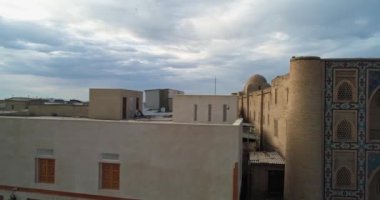 İnsansız hava aracı, antik Lyab-i Hauz kompleksinin ana kapısının yakınında uçuyor. Turist grupları kapının yanında. Eski Buhara, Özbekistan. Hava Görünümü.