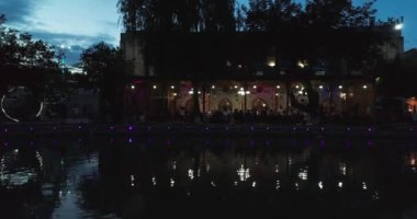 İnsansız hava aracı gece su üzerinde antik Bolo Khauz kompleksinin sütunlarının yanında uçuyor. Eski Buhara, Özbekistan. Hava Görünümü.