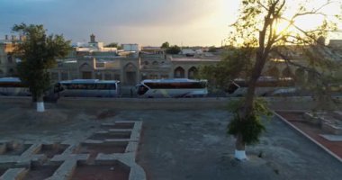 Buhara 'nın antik sandığı yakınlarındaki turist otobüslerinin üzerinden bir İHA uçuyor. Eski Buhara, Özbekistan. Hava Görünümü.