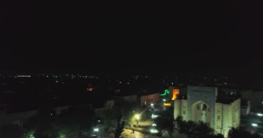 Geceleri Bolo Haouz Camii 'nin önündeki havuzun üzerinde insansız hava aracı. Buhara, Özbekistan, Havadan görünüm.