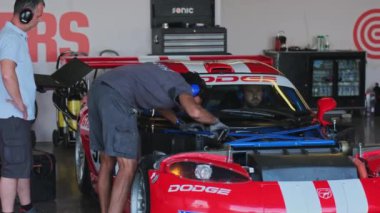 Dubai, BAE - 120 2024: Yarış arabasının teknik ekibi yarış başlamadan önce arabayı kontrol ediyor. Yavaş Hareket