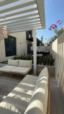 Güneşli bir günde Dubai 'de özel bir villanın arka bahçesinde küçük bir yüzme havuzu ve kanepesi var. Dışarıda ağır çekim.