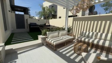 Güneşli bir günde Dubai 'de özel bir villanın arka bahçesinde küçük bir yüzme havuzu ve kanepesi var. Dışarıda ağır çekim.