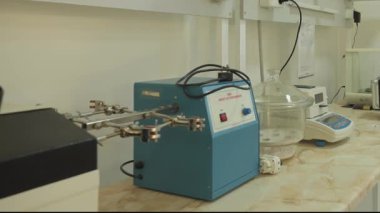 İnsanlar kimya laboratuvarında çalışıyor. Koruyucu giysiler, ekipmanlar, parlak ışıklar. Yavaş Hareket.