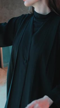 Abaya 'nın Arap milli elbisesi içinde genç bir kadın. Elbisenin yakın çekimi. Yavaş Hareket.