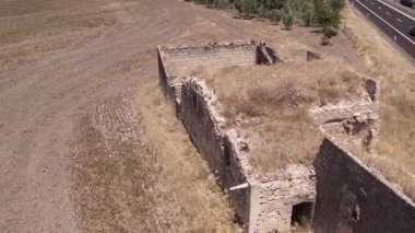 Bulutlu bir günde, bir çiftçi tarlasının ortasında antik bina kalıntıları üzerinde insansız hava aracı. Hava Görünümü