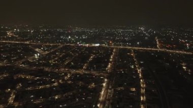 Aydınlanmış bir şehrin üzerinde bir dron. Yaz Gecesi. Hava Görünümü