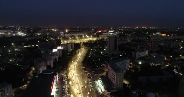 Gece aydınlık bir şehrin üzerinde bir dron. Bulutsuz bir yaz gecesi. Hava Görünümü.