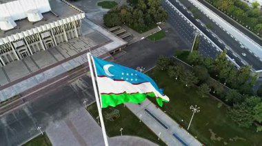 Bir İHA şehrin ortasında dev bir bayrağın üzerinde dalgalanıyor. Hava Görünümü