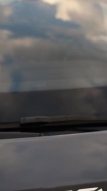 Dubai caddesinde pahalı bir spor arabanın kaputuna yakın çekim. Bulutlu bir yaz akşamı. Yavaş Hareket
