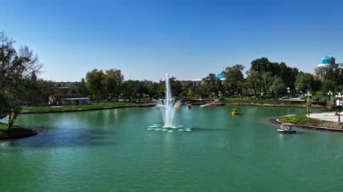 Şehir gölünün üzerinde çeşmelerle dron. Güneşli bir yaz günü. Hava Görünümü, Yavaş Hareket
