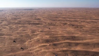 Çöl kum tepecikleri boyunca yürüyen bir grup turist üzerinde bir dron. Dubai, güneşli bir yaz günü. Hava Görünümü