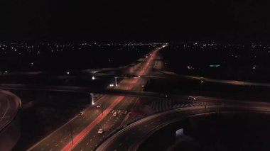 Gece şehrinin ortasında bir müzenin üzerindeki insansız hava aracı ışıklarla aydınlatılıyor. Bulutsuz Yaz Gecesi. Hava Görünümü