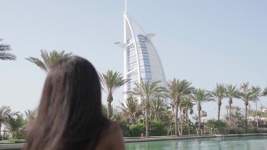 Elbiseli rahat ırklar arası kadın Dubai 'de bir kanaldan geçen bir teknenin pruvasında duruyor. Güzellik, sağlık ve özgüven, yavaş çekim