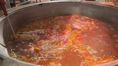 Şef, et çorbasını büyük bir kazanda sebzelerle karıştırıyor. Yavaş Hareket, Kapat.