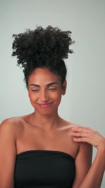 Siyah kıvırcık saçlı ve parlak makyajlı esmer bir kadının portresi. Gülümsüyor ve gülüyor. Kapat, Yavaş Hareket