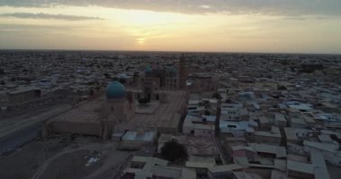 Özbekistan 'ın Buhara kentindeki eski evler arasında Poi-Kalon mimari kompleksinin üzerinde bir dron uçuyor. Erkenden bulutlu bir sabah. Hava Görünümü.
